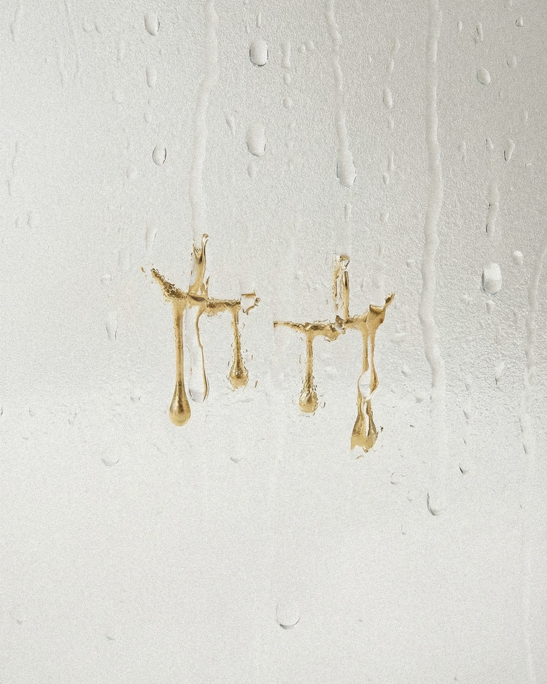 Gold earrings on a textured white background